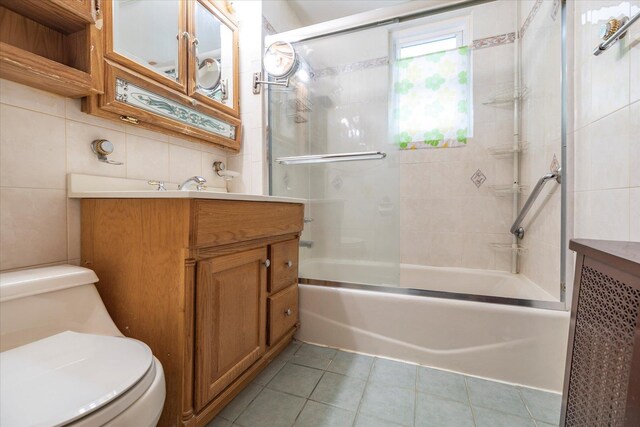 120-05 115th Ave, South Ozone Park, NY 11420 - bathroom featuring tile patterned flooring, toilet, vanity, enclosed tub / shower combo, and tile walls