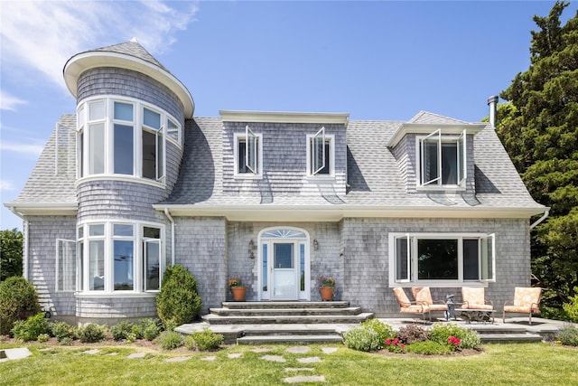 2335 Minnehaha Blvd, Southold, NY 11971 - view of front of home featuring roof with shingles, a patio area, and a front lawn