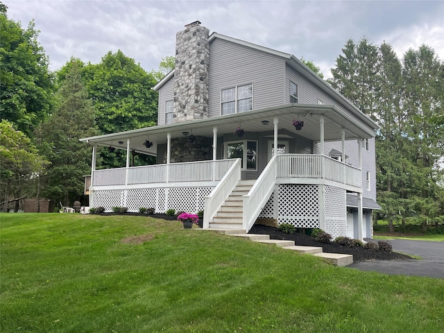 23 Saddle Rock Dr, Poughkeepsie, NY 12603 - view of front of house with stairway, a front yard, a chimney, covered porch, and a garage
