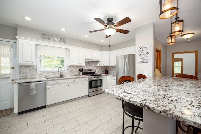 23 Saddle Rock Dr, Poughkeepsie, NY 12603 - kitchen featuring appliances with stainless steel finishes, a sink, a breakfast bar area, backsplash, and a ceiling fan
