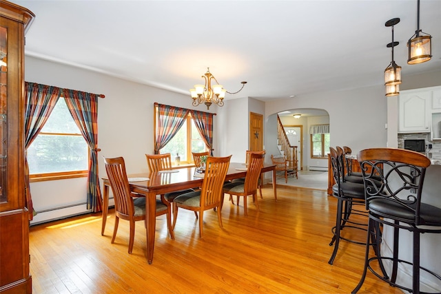 23 Saddle Rock Dr, Poughkeepsie, NY 12603 - dining area with arched walkways, light wood finished floors, a chandelier, stairs, and baseboard heating