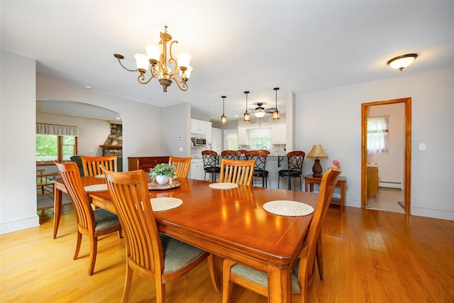 23 Saddle Rock Dr, Poughkeepsie, NY 12603 - dining space with a baseboard heating unit, light wood-style floors, baseboards, a chandelier, and arched walkways