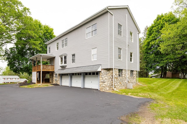 23 Saddle Rock Dr, Poughkeepsie, NY 12603 - view of side of home with a garage, a lawn, stone siding, driveway, and a deck