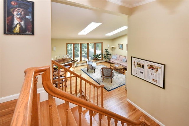 2783 Rita Ct, Bellmore, NY 11710 - stairway featuring a skylight, wood finished floors, lofted ceiling, baseboards, and crown molding