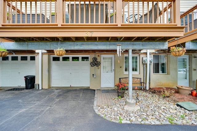 37 Scenic Cir, Croton-On-Hudson, NY 10520 - view of exterior entry featuring a garage, driveway, stucco siding, and a balcony