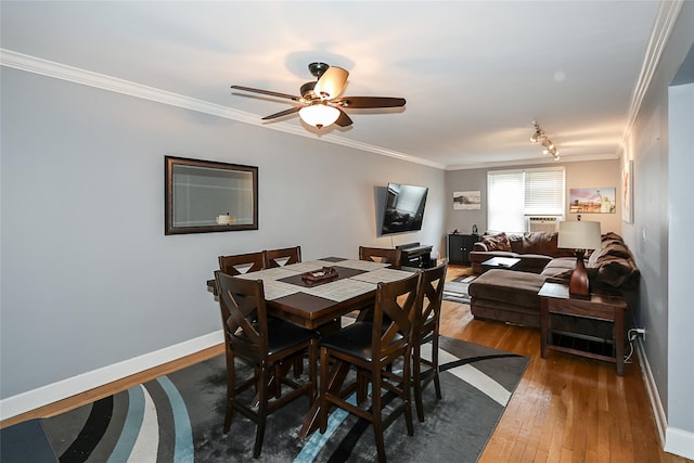 200 N Village Ave Unit D5, Rockville Centre, NY 11570 - dining space with ornamental molding, wood-type flooring, ceiling fan, and baseboards