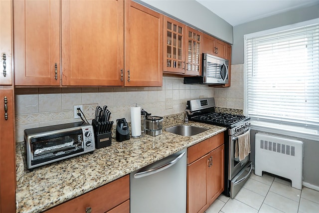 200 N Village Ave Unit D5, Rockville Centre, NY 11570 - kitchen featuring radiator, appliances with stainless steel finishes, and brown cabinets