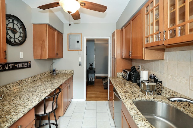 200 N Village Ave Unit D5, Rockville Centre, NY 11570 - kitchen featuring brown cabinetry, electric panel, ceiling fan, backsplash, and light stone countertops
