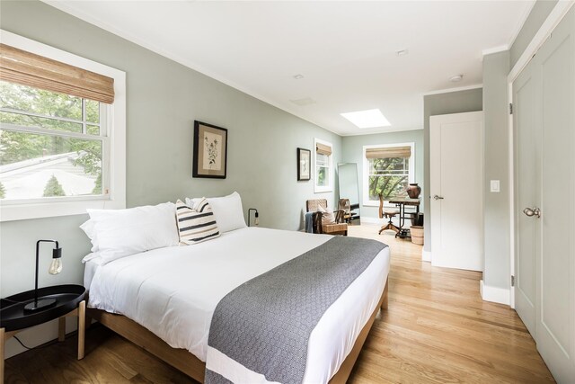 21 Hillside Dr W, Sag Harbor, NY 11963 - bedroom featuring light wood-type flooring, a skylight, crown molding, and baseboards