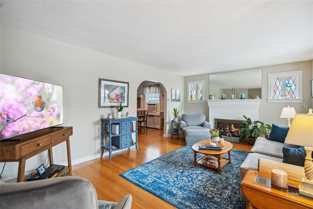 1515 Kenneth Ave, Baldwin, NY 11510 - living area featuring arched walkways, wood finished floors, a fireplace, baseboards, and cooling unit