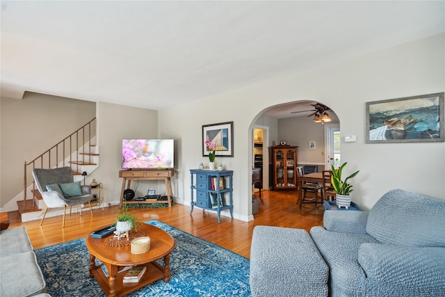 1515 Kenneth Ave, Baldwin, NY 11510 - living room with arched walkways, a ceiling fan, wood finished floors, stairs, and baseboards