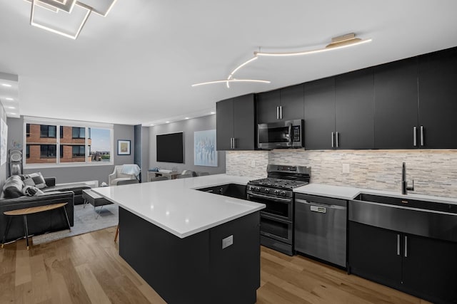 345 E 93rd St Unit 25Ak, New York Manhattan, NY 10128 - kitchen with stainless steel appliances, dark cabinetry, light countertops, a sink, and tasteful backsplash