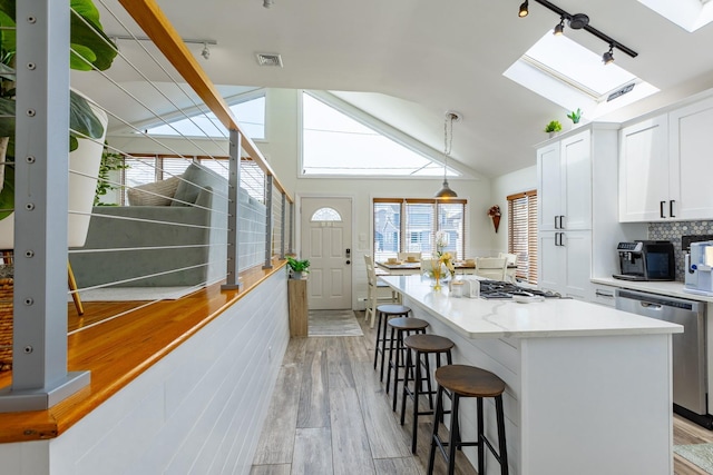 29 Mckinley Ave, Lindenhurst, NY 11757 - kitchen featuring a skylight, track lighting, gas cooktop, stainless steel dishwasher, and vaulted ceiling