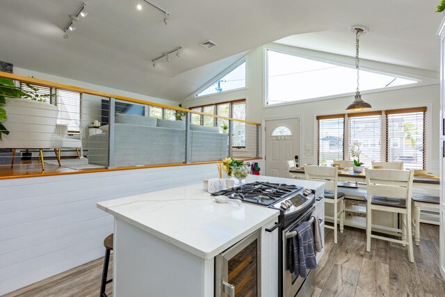 29 Mckinley Ave, Lindenhurst, NY 11757 - kitchen featuring stainless steel gas range, track lighting, wood finished floors, beverage cooler, and vaulted ceiling
