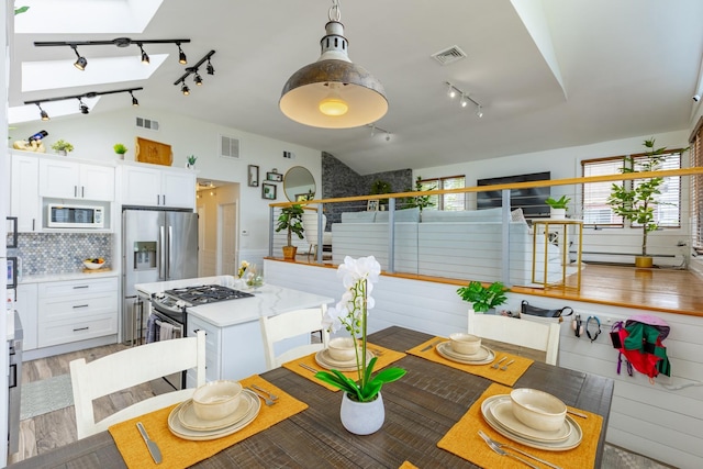 29 Mckinley Ave, Lindenhurst, NY 11757 - dining space with track lighting, lofted ceiling, and light wood finished floors