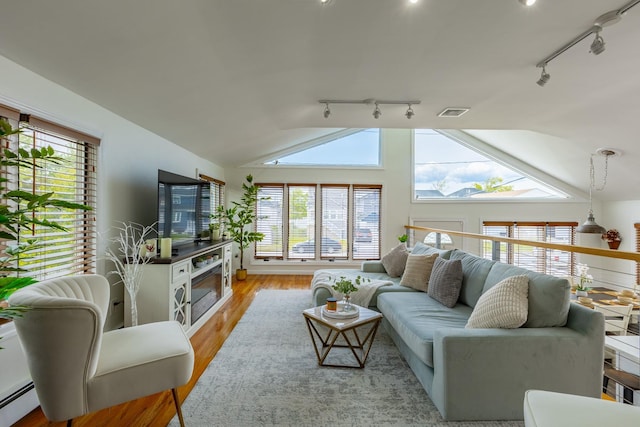 29 Mckinley Ave, Lindenhurst, NY 11757 - living room with rail lighting, a baseboard radiator, lofted ceiling, plenty of natural light, and light wood finished floors
