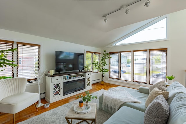 29 Mckinley Ave, Lindenhurst, NY 11757 - living room featuring track lighting, healthy amount of natural light, light wood-style flooring, a baseboard heating unit, and vaulted ceiling