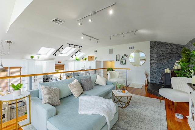 29 Mckinley Ave, Lindenhurst, NY 11757 - living room featuring a skylight, wood finished floors, lofted ceiling, rail lighting, and baseboards
