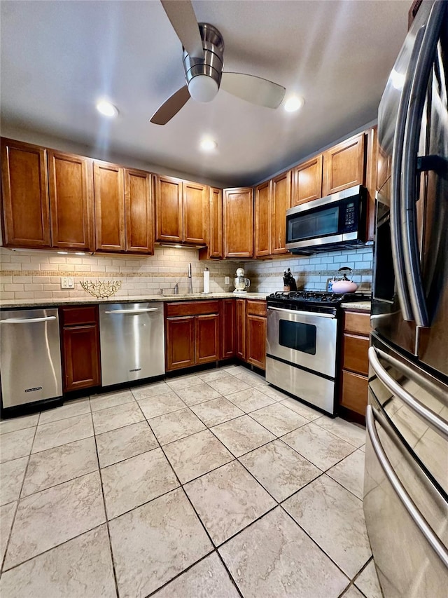 315 King St Unit 6H, Port Chester, NY 10573 - kitchen with stainless steel appliances, decorative backsplash, a sink, brown cabinets, and a ceiling fan