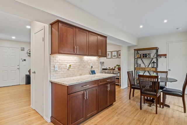 12 Franklin Commons, Yaphank, NY 11980 - kitchen featuring light wood-style flooring, backsplash, recessed lighting, and light stone countertops