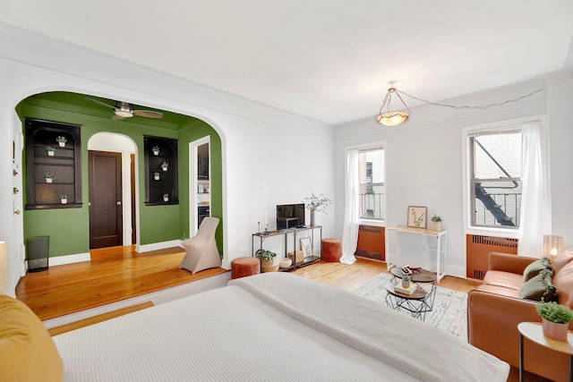 50 Lefferts Ave Unit 6M, Brooklyn, NY 11225 - bedroom with radiator heating unit, light wood-type flooring, arched walkways, and baseboards