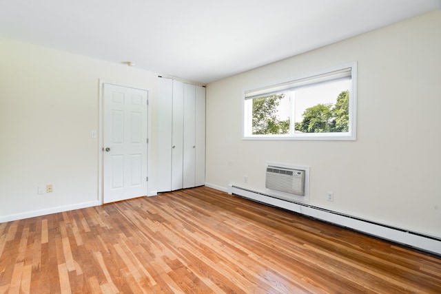 10 Fishkill Glen Dr Unit G, Fishkill, NY 12524 - unfurnished bedroom with a baseboard heating unit, a wall mounted AC, light wood-type flooring, and baseboards