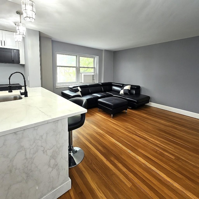 89-25 Shore Pkwy Unit 1L, Howard Beach, NY 11414 - living area with wood finished floors, baseboards, and cooling unit