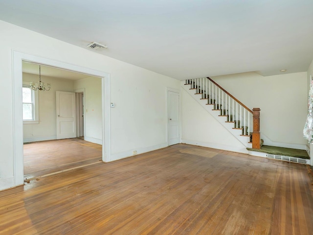 3 3rd St, Glenwood Landing, NY 11547 - unfurnished living room featuring a chandelier, light wood-type flooring, stairway, and baseboards