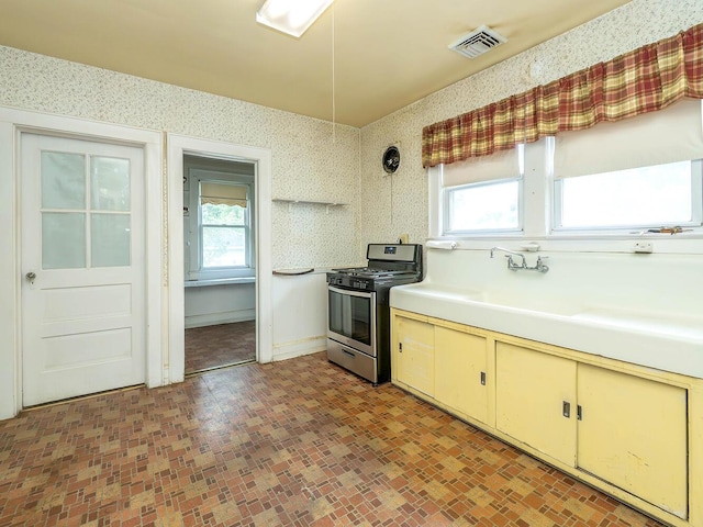 3 3rd St, Glenwood Landing, NY 11547 - kitchen featuring stainless steel gas range oven, wallpapered walls, healthy amount of natural light, light countertops, and baseboards