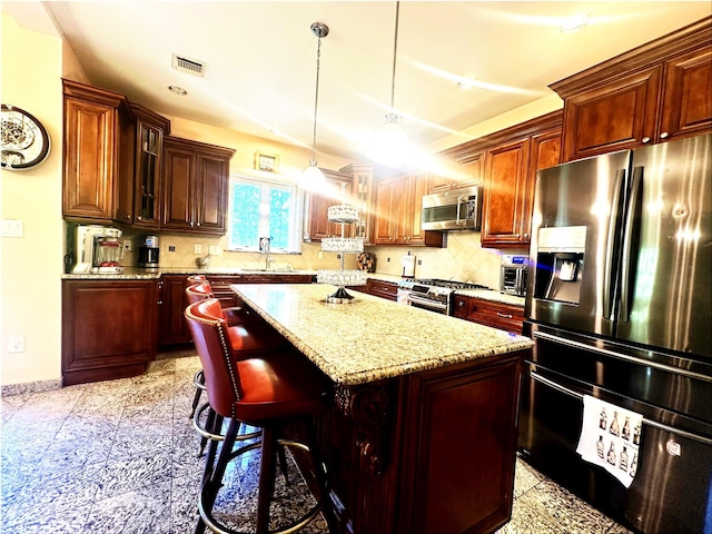 344 Ingrassia Rd, Middletown, NY 10940 - kitchen featuring stainless steel appliances, a center island, light stone countertops, hanging light fixtures, and a breakfast bar area