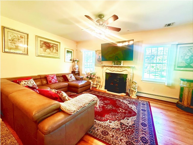 344 Ingrassia Rd, Middletown, NY 10940 - living room featuring a baseboard radiator, a ceiling fan, wood finished floors, and a fireplace