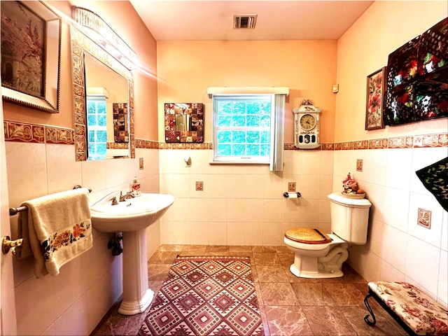 344 Ingrassia Rd, Middletown, NY 10940 - bathroom with tile walls, plenty of natural light, toilet, a wainscoted wall, and tile patterned flooring