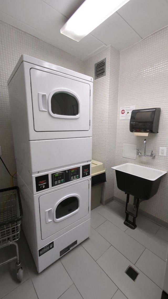 16 Rockledge Ave Unit 5B1, Ossining, NY 10562 - community laundry room with stacked washer and clothes dryer, tile patterned flooring, and tile walls