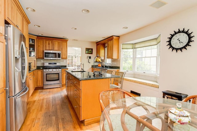 21 Maple Rd, Setauket, NY 11733 - kitchen featuring appliances with stainless steel finishes, a sink, light wood-style floors, backsplash, and brown cabinets