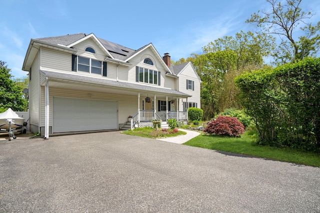 106 S Country Rd, Westhampton Beach, NY 11978 - view of front of house with covered porch, roof mounted solar panels, asphalt driveway, and an attached garage