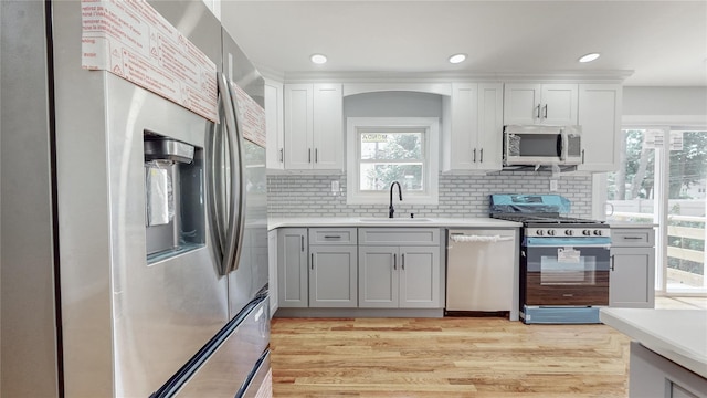 596 Terrace Pl, Baldwin, NY 11510 - kitchen with stainless steel appliances, a sink, light countertops, decorative backsplash, and recessed lighting