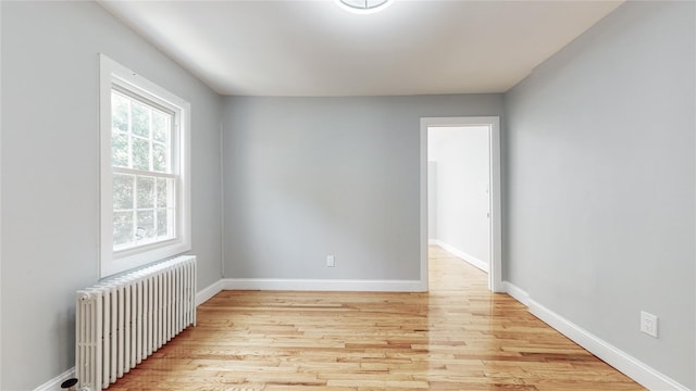 596 Terrace Pl, Baldwin, NY 11510 - empty room with radiator, light wood-style flooring, and baseboards