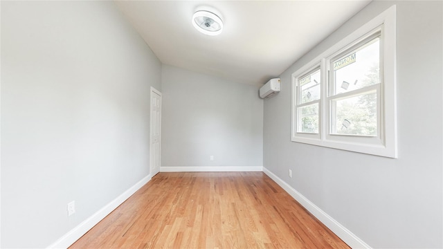 596 Terrace Pl, Baldwin, NY 11510 - spare room with an AC wall unit, light wood-type flooring, and baseboards