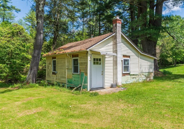 750 Irish Cape Rd, Ellenville, NY 12428 - back of property featuring a chimney, a yard, and roof with shingles