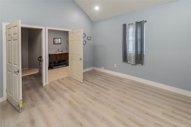 750 Irish Cape Rd, Ellenville, NY 12428 - unfurnished bedroom featuring baseboards, light wood finished floors, a sink, and high vaulted ceiling