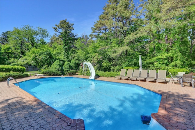 10 Charter Ct, Dix Hills, NY 11746 - swimming pool featuring a water slide, a patio area, a diving board, and view of scattered trees