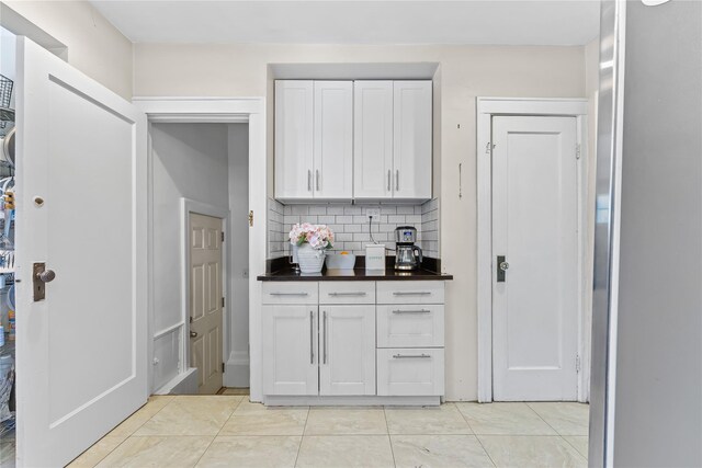 70-27 Olcott St, Forest Hills, NY 11375 - kitchen with dark countertops, decorative backsplash, and white cabinets