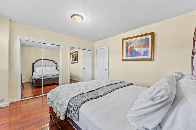 70-27 Olcott St, Forest Hills, NY 11375 - bedroom featuring two closets and wood-type flooring