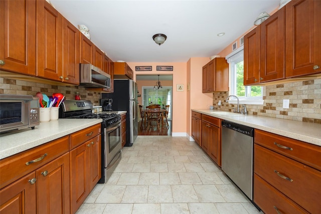 90 Fieldstone Blvd, Wappingers Falls, NY 12590 - kitchen with stainless steel appliances, a sink, light countertops, and tasteful backsplash