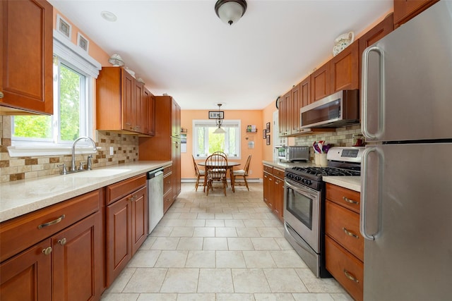 90 Fieldstone Blvd, Wappingers Falls, NY 12590 - kitchen featuring stainless steel appliances, tasteful backsplash, a sink, and brown cabinetry