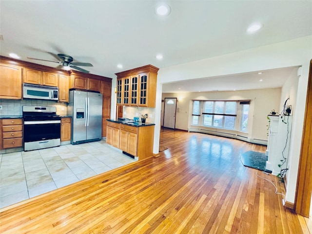 24 Gaymor Ln, Commack, NY 11725 - kitchen with appliances with stainless steel finishes, dark countertops, light wood-style floors, glass insert cabinets, and decorative backsplash