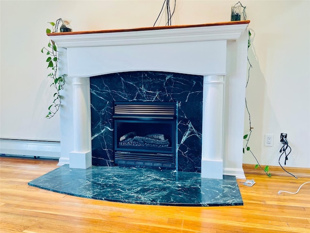 24 Gaymor Ln, Commack, NY 11725 - detailed view of a high end fireplace, wood finished floors, and baseboard heating