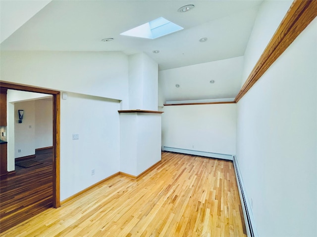 24 Gaymor Ln, Commack, NY 11725 - spare room featuring a skylight, wood finished floors, a baseboard heating unit, a baseboard radiator, and lofted ceiling