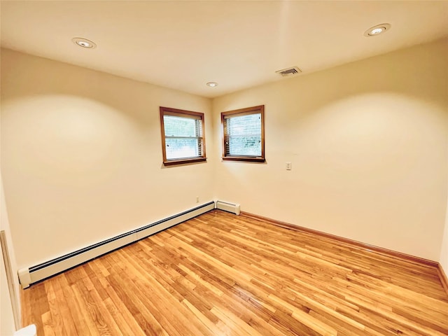 24 Gaymor Ln, Commack, NY 11725 - empty room featuring a baseboard heating unit, light wood-style floors, recessed lighting, and baseboards