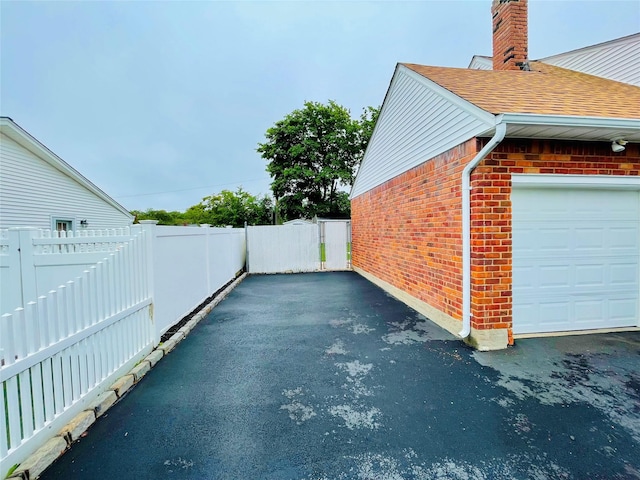 24 Gaymor Ln, Commack, NY 11725 - view of home's exterior with brick siding, a garage, roof with shingles, and a chimney
